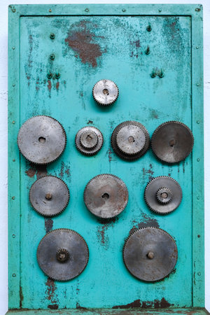 Gear wheels of industrial machinery, disused in a workshop.