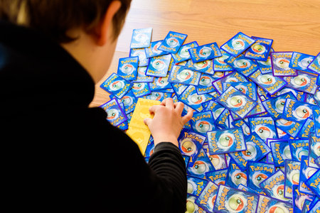 Valencia, Spain - January 10, 2023: A single boy male hand holds a pokemon trading card game.