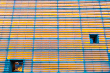 Background of yellow symmetrical lines with real lighting on a wallの写真素材