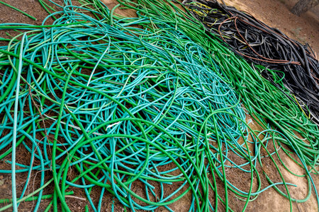 Remains of plastic electrical cables abandoned in a field by thieves.