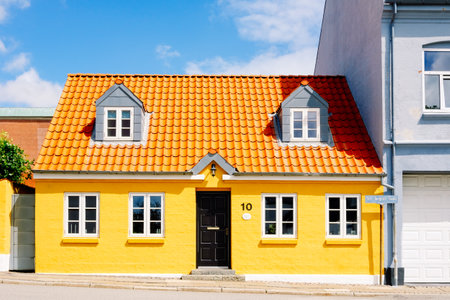 Nice colorful one storey house of traditional brick construction, painted yellow, in a Danish town.の写真素材
