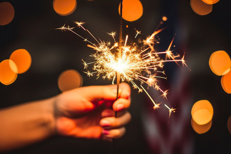 young man joyfully waves a sparkler, lighting up the American spirit on a festive occasionの素材