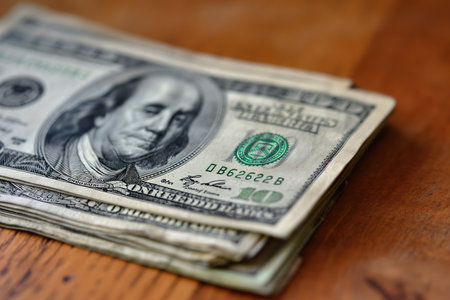 Several dollar bills on the table, out of focus, with copy space.の素材