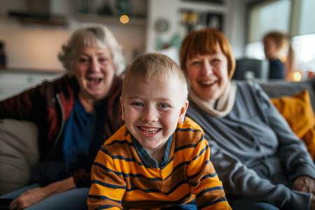 Older woman and young boy with Down Syndrome sitting on couch.の素材