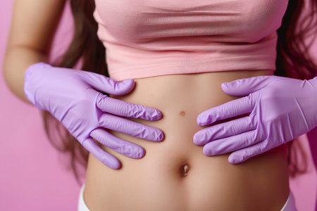 A dermatologist examining a young woman's stomach adorned with purple gloves, focusing on moles and skin assessment.の素材