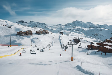 A ski lift rises up the side of a snow-covered mountain on a clear day.の素材