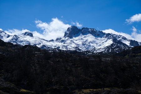 A snow-covered mountain range in the distance, featuring the majestic Picos de Europa mountains in Asturias. The snow-capped peaks stood out against the sky, creating a striking landscape.の写真素材