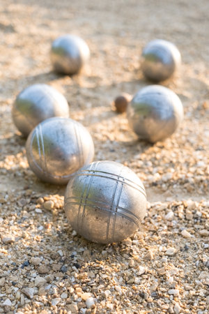 Petanque balls on the ground, detail in foreground, typical French game.の写真素材