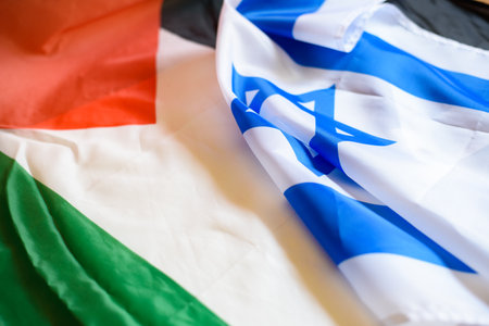 The intertwined flags of Israel and Palestine reflect the complex and tumultuous relationship marked...