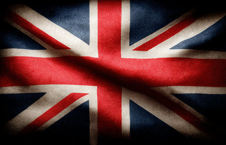 Extreme close-up of the Union Jack flag showing its historical fabric and intricate design details that represent British identity and heritage.の素材