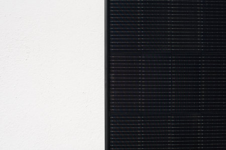 A close-up view shows the detailed surface of a solar photovoltaic panel. The shot captures the grid...