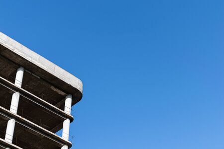 Abandoned construction building corner against blue skyの写真素材