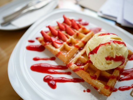 Strawberry waffles served with vanilla ice cream.の写真素材