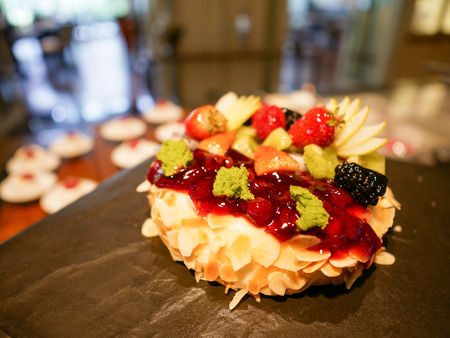 Whole cheesecake with almond sliced and decorated with strawberries, raspberries, apples.の写真素材