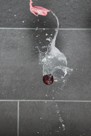 High speed photography of a cherry in a water balloon poppingの写真素材