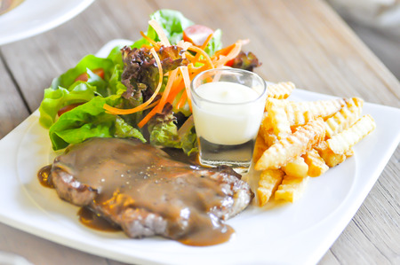 pork steak, French fries  and salad dishの写真素材