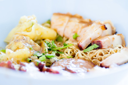 Noodles with crispy pork , dumpling and parsley dishの写真素材