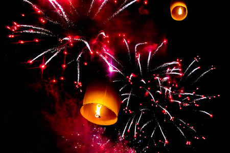 Sky lantern and fireworks in the night skyの写真素材