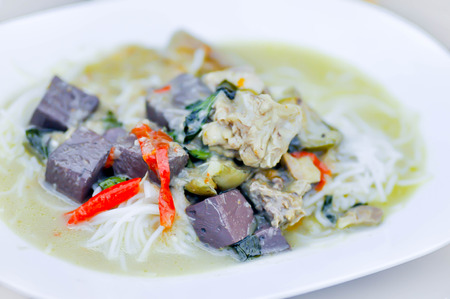 Thai green curry  noodles served on white dishの写真素材