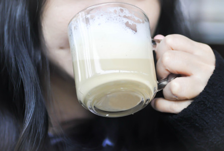 a woman's drinking a cup of coffeeの写真素材
