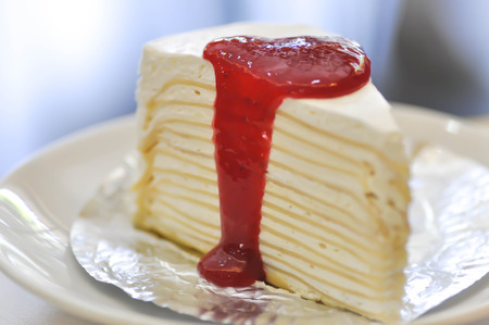 a piece of crepe cake with strawberry dressing