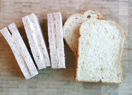 bread or ham and cheese sandwich on wooden tray