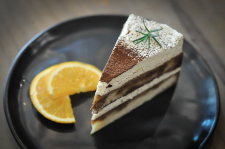 a piece of cake or tiramisu cake and orangeの写真素材