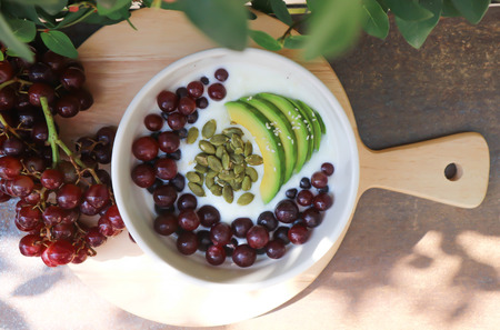 yogurt with grape, avocado and water melon seed toppingの写真素材