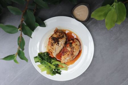 grilled chicken or chicken steak with sauce and vegetableの写真素材