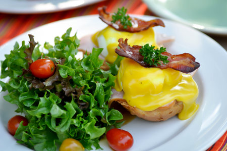 egg benedict or bun with egg , ham and bacon topping