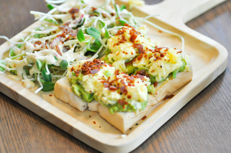 salad and avocado toast ,sunflower sprout salad with bacon topping dish