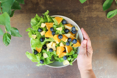 fruit and vegetable salad or blueberry , apple and orange salad with lettuce for serveの写真素材