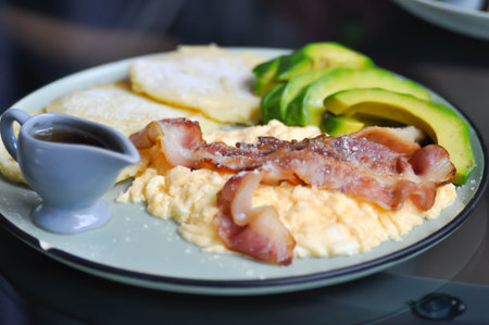 omelette , omelet or scrambled egg with bacon or pancake and avocado with syrup or honeyの写真素材
