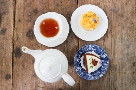 hot tea, English tea or tea cup and tea pot with carrot cake and mango cakeの写真素材