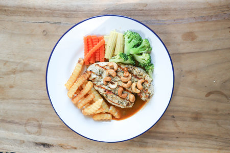 grilled chicken or chicken steak with gravy sauce , French fries and vegetable in top viewの写真素材