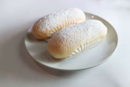 bun, bread or butter bread wih icing sugar topping