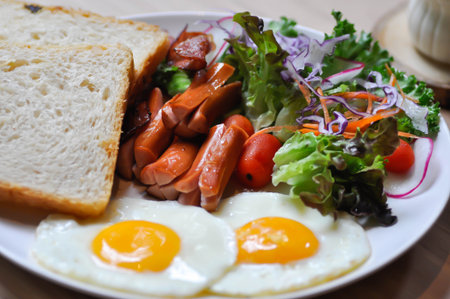 breakfast or bread with sunny side up egg, sausage and vegetable and hot coffee for serveの写真素材