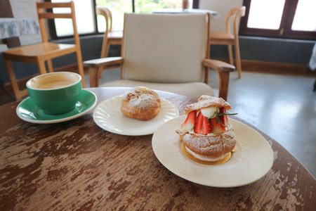 choux cream or cream puff, eclair or strawberry choux cream  and coffee on the table