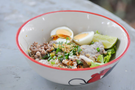 Chinese noodles with pork and eggl or noodles without soup or plain noodles or noodles saladの写真素材