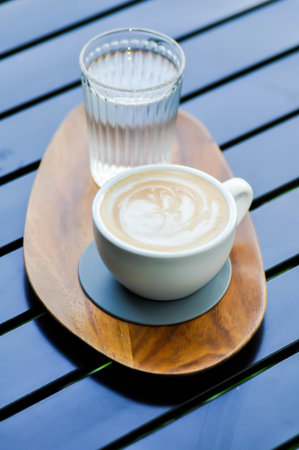 hot cofffee, cappuccino coffee or latte coffee or flat white and water on the tableの写真素材