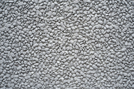 Grey painted pebble stones on a wall as a background motive