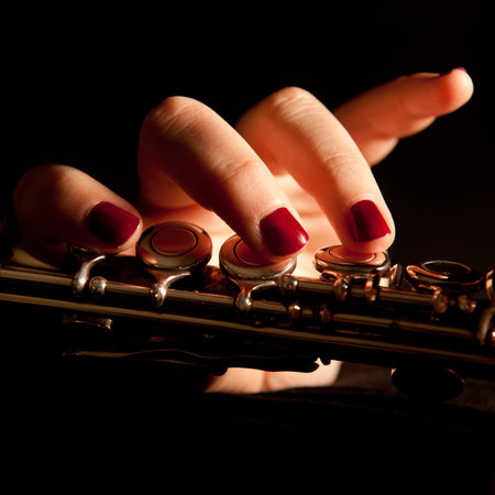 Fingers of a young woman playing transverse flute, closeup の写真素材