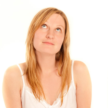 Portrait of a cute female in white nightshirt looking upwardsの写真素材