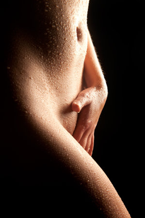 Naked wet body of a sexy woman touching herselfの写真素材
