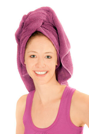 Closeup portrait of beautiful young woman with towel on her head after washing her hair, isolated on whiteの写真素材