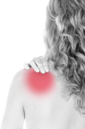 Rear view of a young woman holding her neck in pain, isolated on white background, monochrome photo with red as a symbol for the hardeningの写真素材