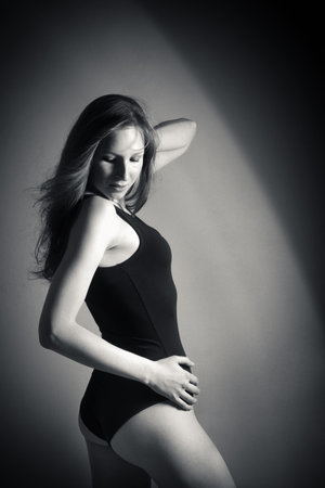 Fashion portrait of attractive brunette woman in black bodysuit, monochrome photoの写真素材