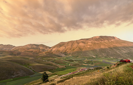 sunset on mountains and fields landscape. Castelluccio di Norcia. italy. Filtered image.の写真素材