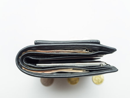 Black purse with paper and iron money on white backgraund