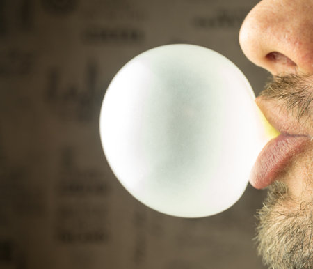 Bearded guy inflates a bubble of gumの写真素材